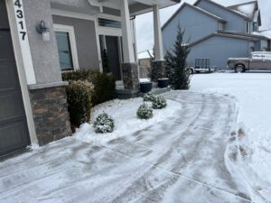 Professional residential snow removal service on a driveway and walkway by Eco Verde Landscaping and Snow Removal LLC in Independence, MO.