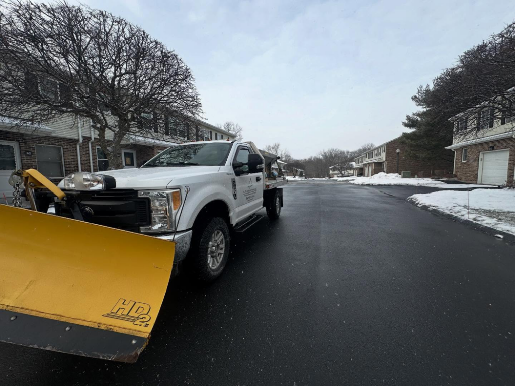 A snow plow truck on a cleared residential street after snow removal by M.J.D Landscape Solutions, LLC in West Hartford, CT.
