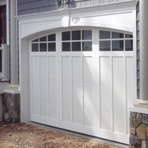 A newly installed white residential garage door with arched windows by American Dock & Door Co. in Warwick, RI.