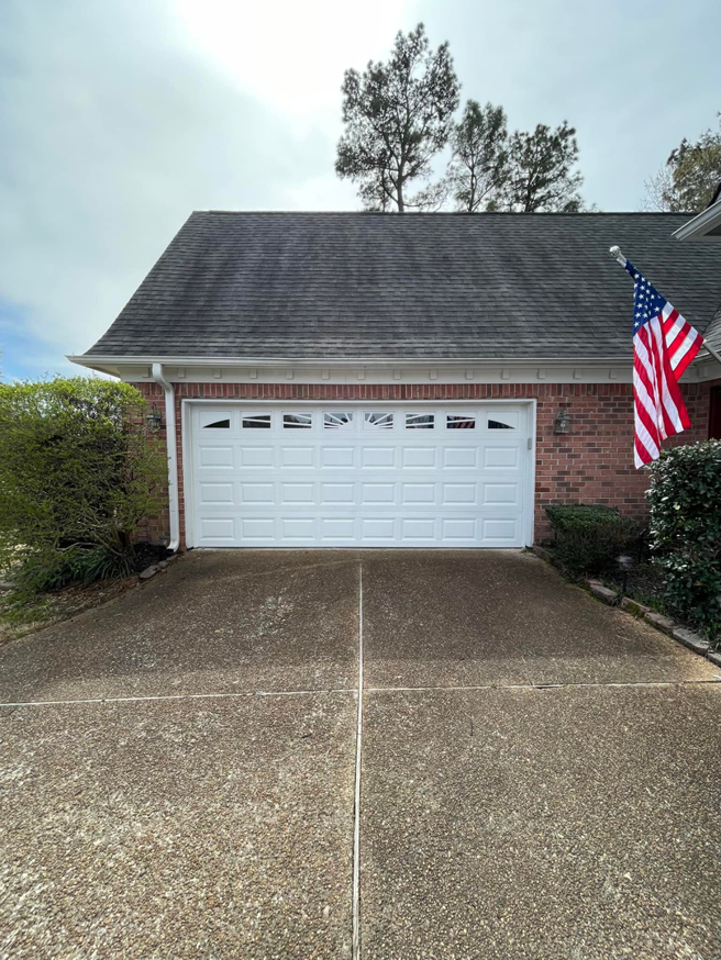 A clean white residential garage door on a brick house, installed by Ultimate Garage Doors LLC in Olive Branch, MS.