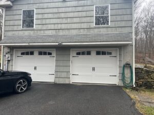 Two new white residential garage doors with decorative hardware, installed by RidgeLine Overhead Garage Door of CT in Danbury, CT