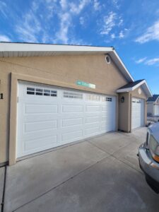 Two white panel garage doors installed on a residential home by 775 Overhead Doors in Carson City, NV.