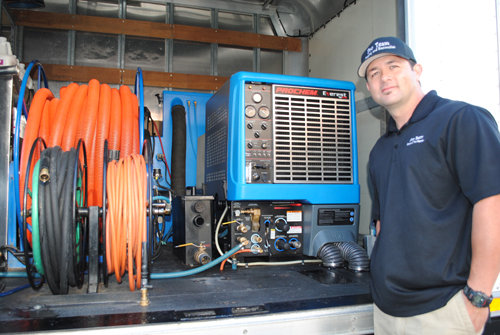 A water damage restoration technician standing by advanced drying equipment in a service truck for Water Damage Pro in Minneapolis, MN