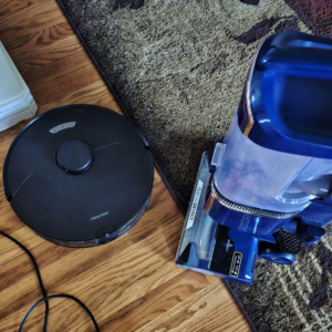 A robot vacuum and an upright stick vacuum cleaner ready for use by Mountain Life Services LLC in Colorado Springs, CO.