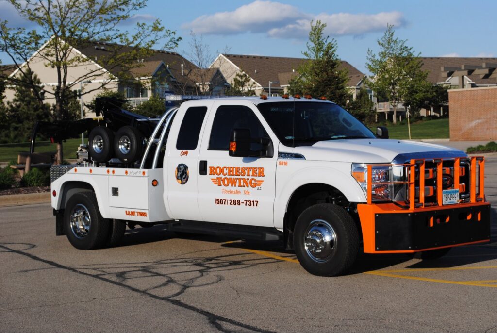 A white Rochester Towing truck parked in a residential parking lot in Rochester, MN.