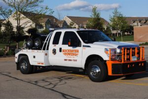 A white Rochester Towing truck parked in a residential parking lot in Rochester, MN.