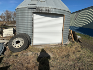 A newly installed white rolling garage door on a metal building by JTL Garage Doors in Fargo, ND.