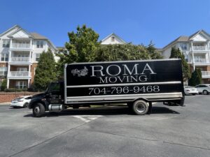 A Roma Moving truck parked in front of an apartment complex, ready for a residential move in Charlotte, NC.
