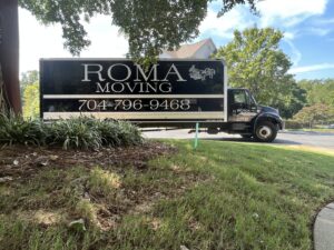 A Roma Moving truck parked in a leafy residential area in Charlotte, NC, ready for a move.