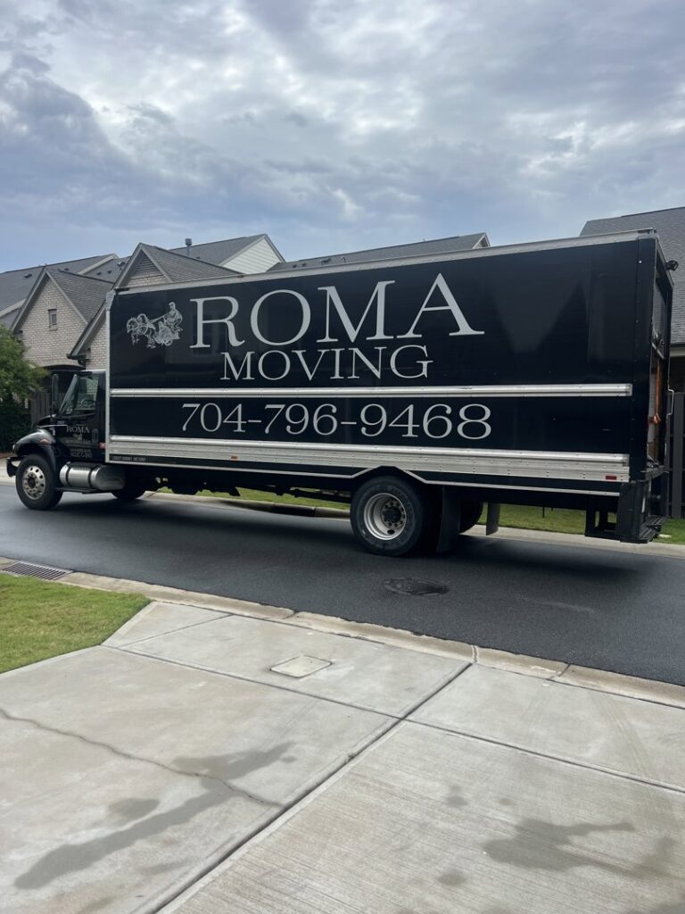 A Roma Moving truck parked on a residential street under a cloudy sky in Charlotte, NC.