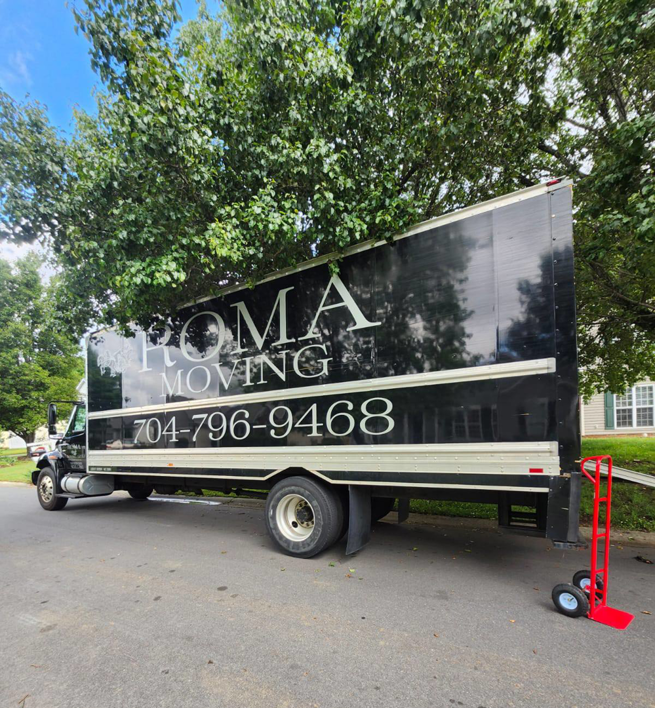A Roma Moving truck with a red hand truck (dolly) parked on a street in Charlotte, NC, ready for a job.