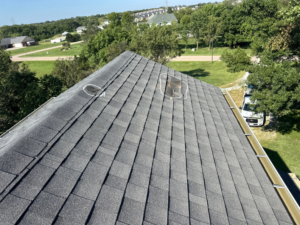 An aerial view of a shingled roof with marked damage areas for water damage assessment by Sharp Restoration in Lincoln, NE.