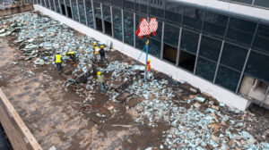 Aerial view of a rooftop demolition project with workers and a crane, managed by Nuckles Services in Birmingham, AL