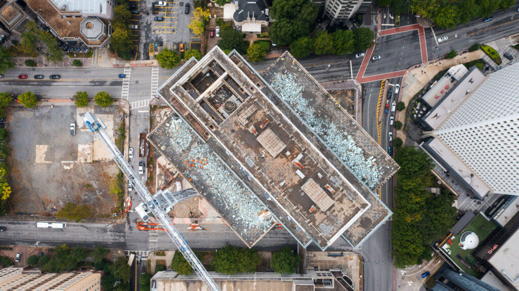 Aerial view of workers performing rooftop demolition and debris removal on a commercial building for Nuckles Services in Birmingham, AL