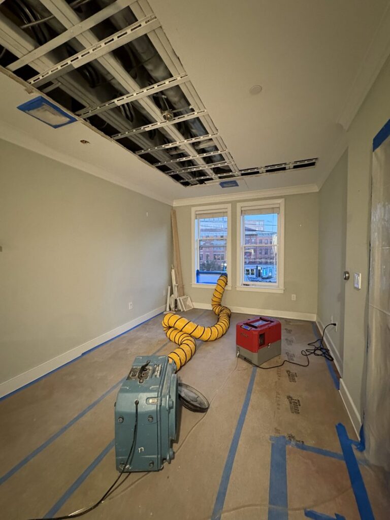 A room with a removed ceiling and drying equipment for water damage restoration by Mold Master Restoration in Jersey City, NJ