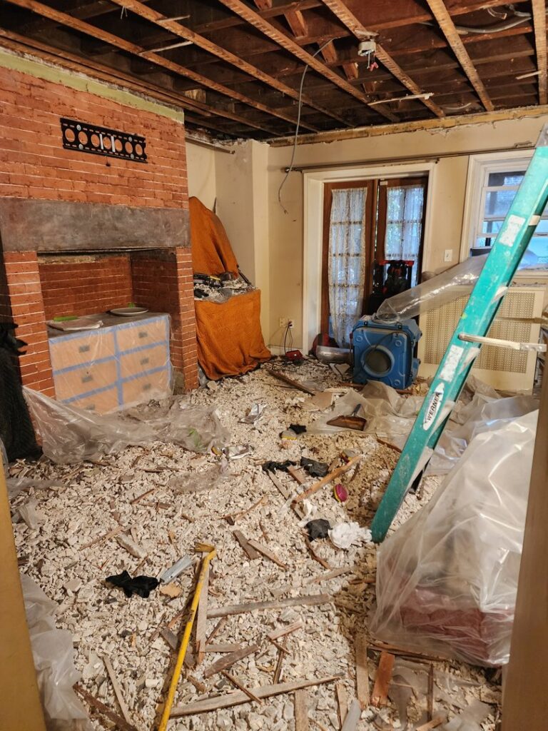 A room with demolition debris and drying equipment during water damage restoration by New Method Restoration in Edison, NJ.