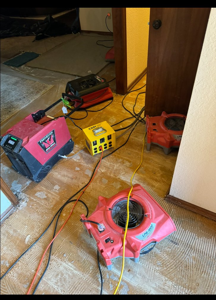 Water damage drying equipment, including air movers and a power box, set up in a room by Paul Davis of Norman & SW OKC in Norman, OK.