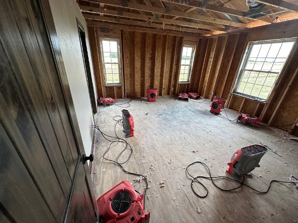 Multiple air movers and drying equipment set up in a room undergoing water damage restoration by Paul Davis of Norman & SW OKC in Norman, OK.
