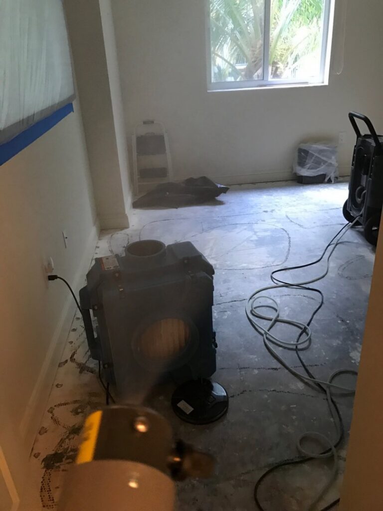 A room undergoing water damage restoration with air movers, dehumidifiers, and a fogging device in use by Southcoast Cleaning Solutions & Restoration in Fall River, MA.