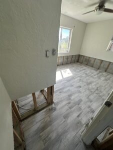 A room with lower drywall removed and new flooring installed after water damage restoration by Catalyst Restoration in Hagerstown, MD.