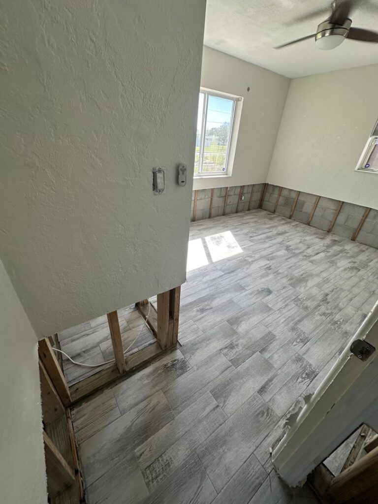 A room with lower drywall removed and new flooring installed after water damage restoration by Catalyst Restoration in Hagerstown, MD.