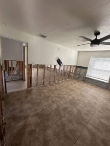 A room with lower drywall removed, exposing studs and concrete blocks during water damage remediation by Catalyst Restoration in Hagerstown, MD.