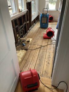 A room undergoing water damage remediation and drying with exposed studs and equipment by CleanBright Surface Restoration in Latham, NY.