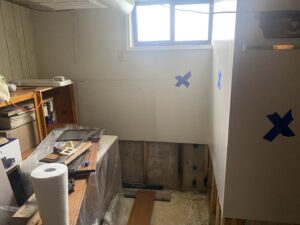 A room undergoing water damage repair with walls removed and exposed studs marked with blue tape by ServiceMaster of Salt Lake in Salt Lake City, UT