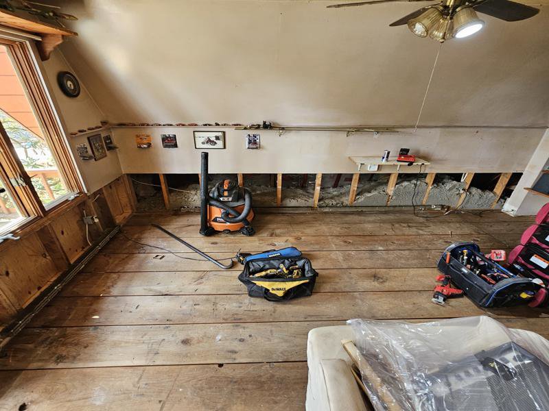 A room with partial wall removal, exposed studs, and a shop vac, for water damage cleanup by PuroClean of Strafford County in Nottingham, NH.