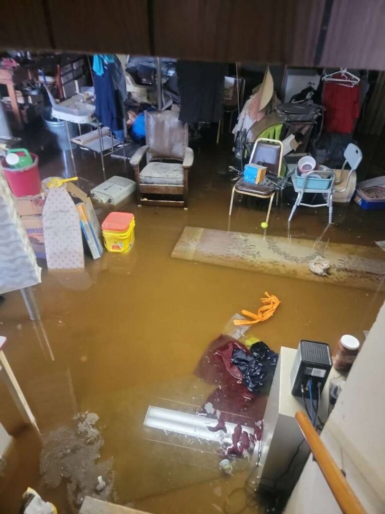 A room with significant standing brown floodwater, indicating severe water damage by North Shore Restore in Duluth, MN
