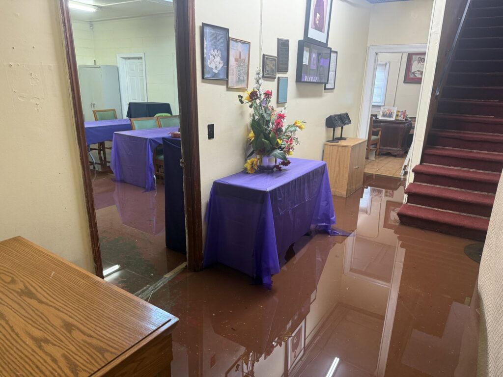 A room with significant standing water from a flood, requiring water damage services from Minutemen Property Damage Services in North Charleston, SC.