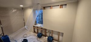 A room with plastic containment and air movers for water damage drying by Harbaugh Restoration in Vancouver, WA.