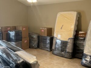 A room filled with wrapped furniture and boxes, prepared for moving by Household Goods Moving and Storage in Rockville, MD