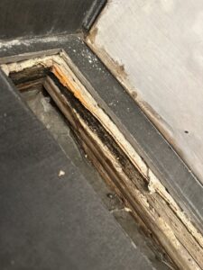 Close-up of rotted wood flooring and subfloor showing severe water damage and discoloration, requiring expert repair from Standard Restoration in Salt Lake City, UT.