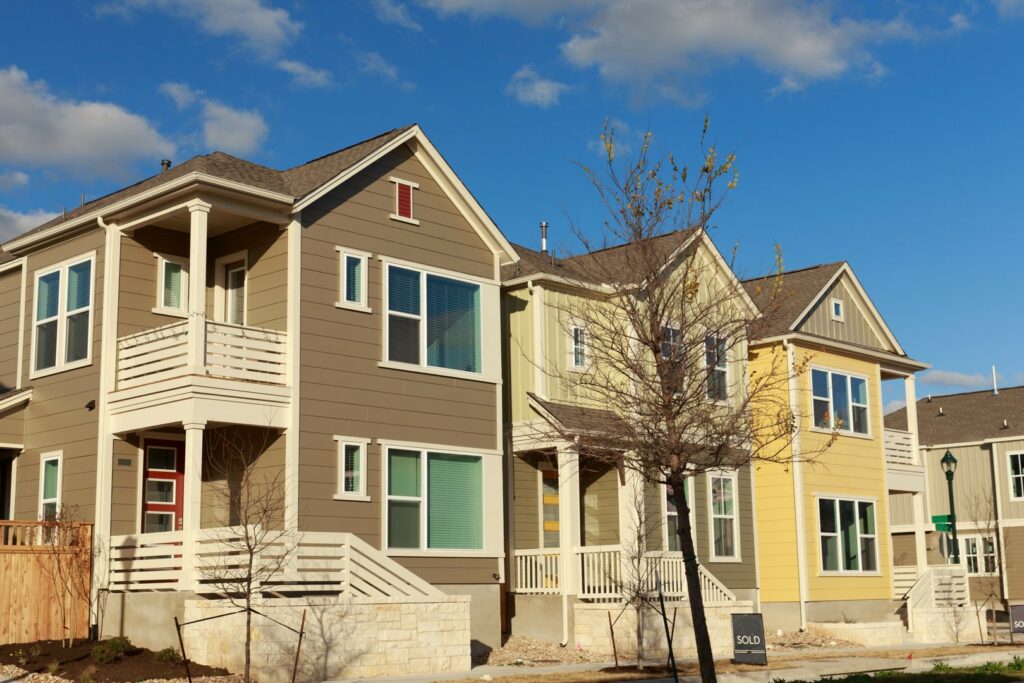 A row of colorful houses showcasing various siding styles, expertly installed by Jonesboro Siding, Window & Door in Jonesboro, AR.