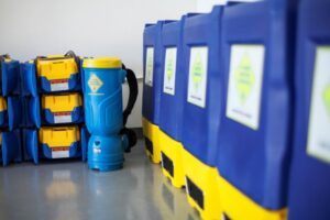 Rows of blue and yellow water damage dehumidifiers and air movers, showcasing equipment used by 1-800 WATER DAMAGE of Oklahoma City, OK.