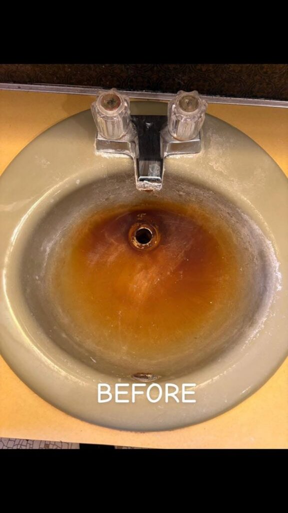 A rust-stained green bathroom sink before deep cleaning by Teri Lynn's Cleaning in Williston, ND.