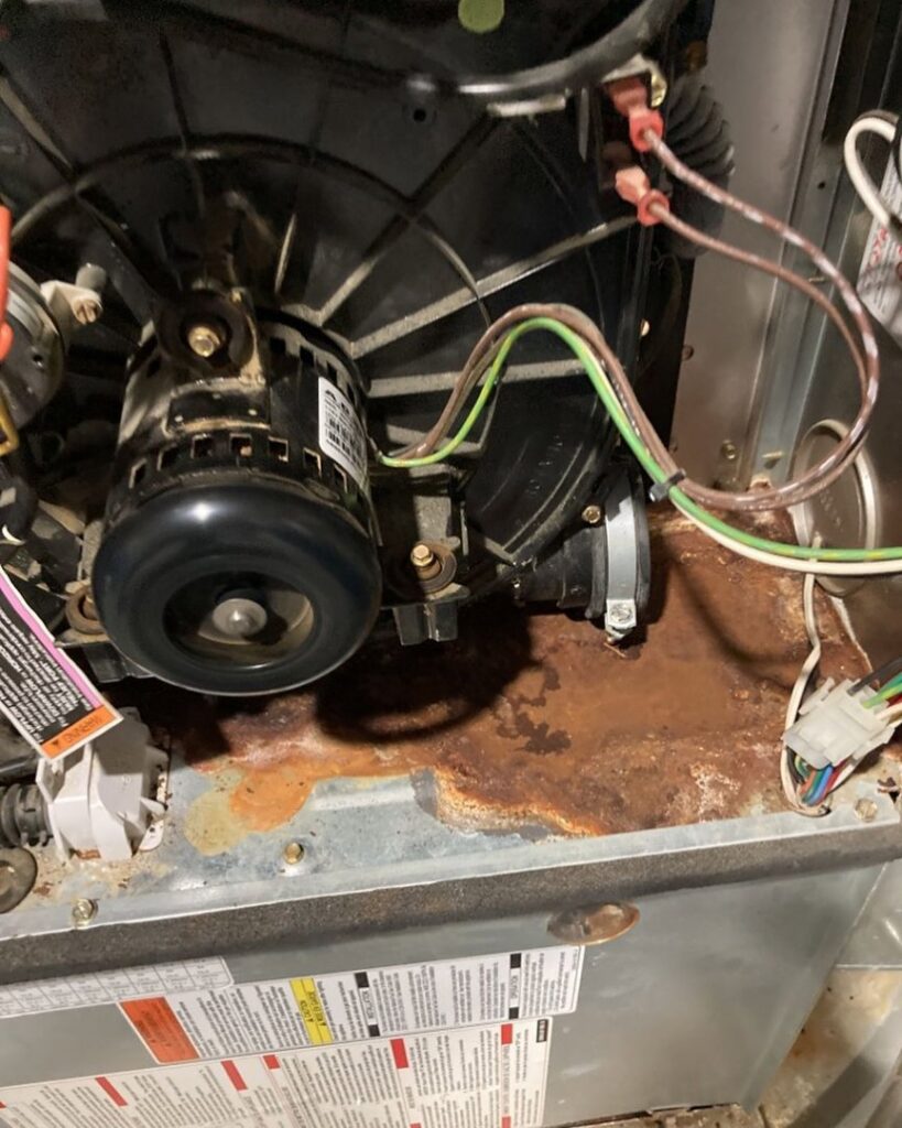 Significant rust and water damage inside an HVAC furnace unit, inspected by Double H Inspections in Sheridan, WY