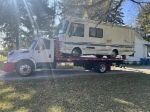 A large RV or motorhome being towed on a flatbed tow truck by Quiñones Towing in Cleveland, OH.