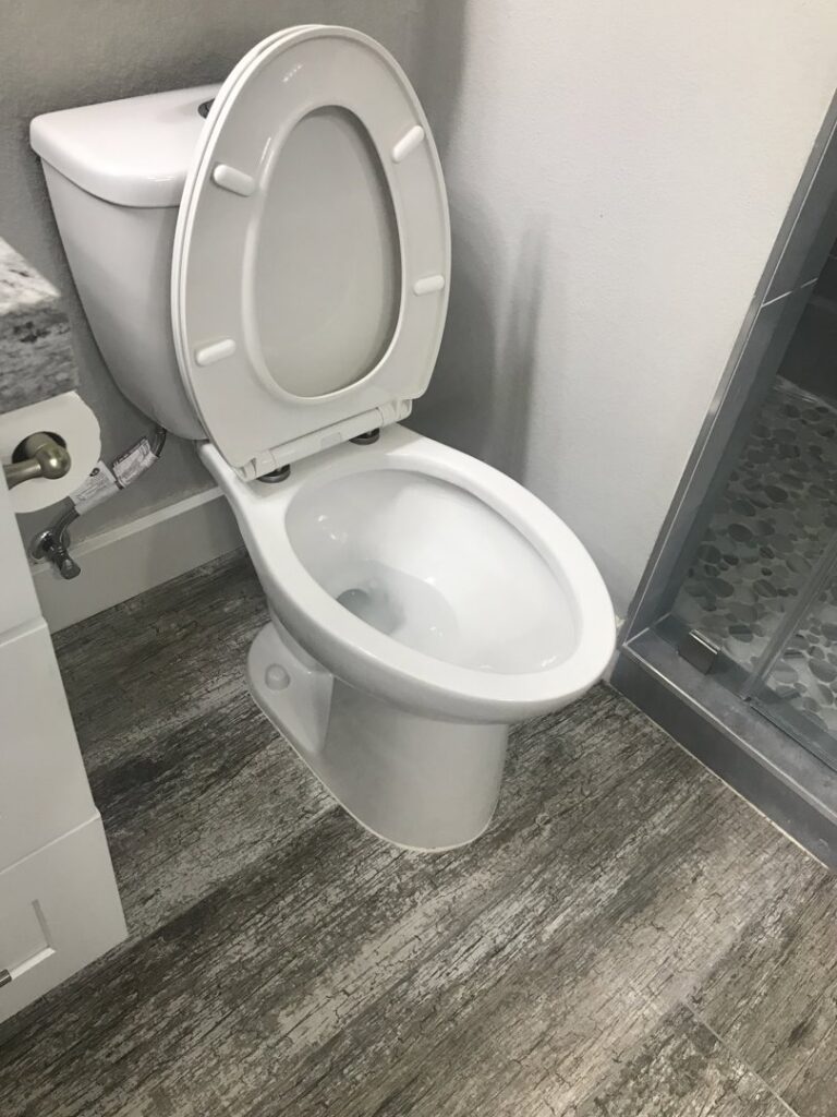 A sanitized and sparkling clean toilet in a modern bathroom, demonstrating A Clean Xscape LLC's house cleaning in Chandler, AZ.