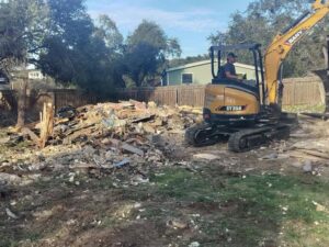 A SANY excavator next to a large pile of demolition debris after a job by San Antonio Demolition Pros in San Antonio, TX.