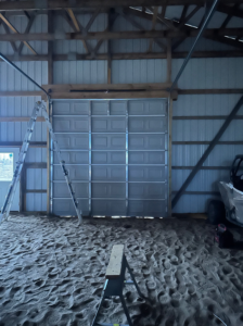 Installation of a new sectional garage door inside a barn by JTL Garage Doors in Fargo, ND.