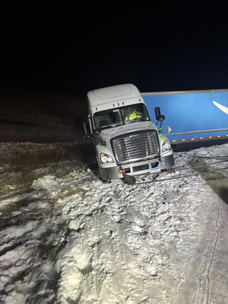 A semi-truck stuck in a snowy ditch awaiting recovery by Diversified Towing and Recovery, LLC in Creston, IA.