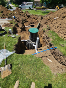 A large excavation site for septic system repair or installation by Western Iowa Utilities in Council Bluffs, IA, preventing water damage.