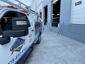 The Door Man - Garage Doors & Openers service truck at a commercial building with loading dock doors in Reno, NV
