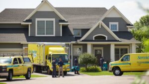 ServiceMaster DSI team with restoration vehicles and equipment arriving at a residential job site in Maple Grove, MN.
