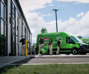 A SERVPRO of Brandywine/Wilmington crew carrying drying equipment from a green van at a job site in Wilmington, DE.