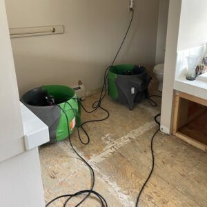 SERVPRO of Barre, Montpelier drying equipment operating in a water-damaged bathroom with exposed subfloor in Barre, VT.