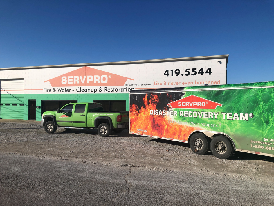 The Servpro - Northwest Arkansas facility with a green truck and disaster recovery trailer for water damage cleanup in Springdale, AR.