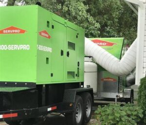 Large SERVPRO of Brandywine/Wilmington drying equipment with ducts set up outside a building for water damage restoration in Wilmington, DE.